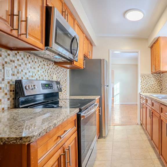 a kitchen with wooden cabinets and a tile backsplash integrity realty, cleveland, oh