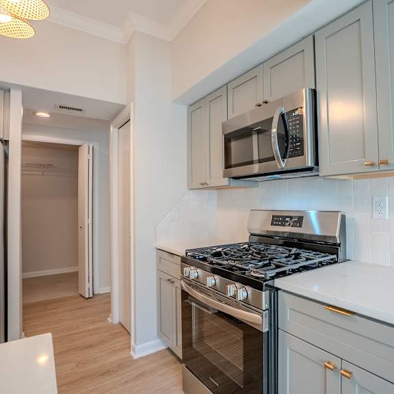 a kitchen with a stove, microwave, and refrigerator t atrium in the village, beachwood, oh 44122