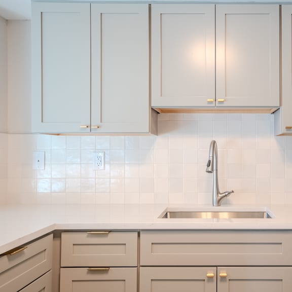 a kitchen with white cabinets and a stainless steel refrigerator t atrium in the village, beachwood, oh 44122