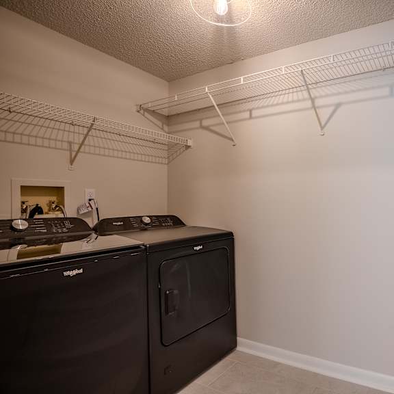a kitchen with white walls and a black counter top t atrium in the village, beachwood, ohio