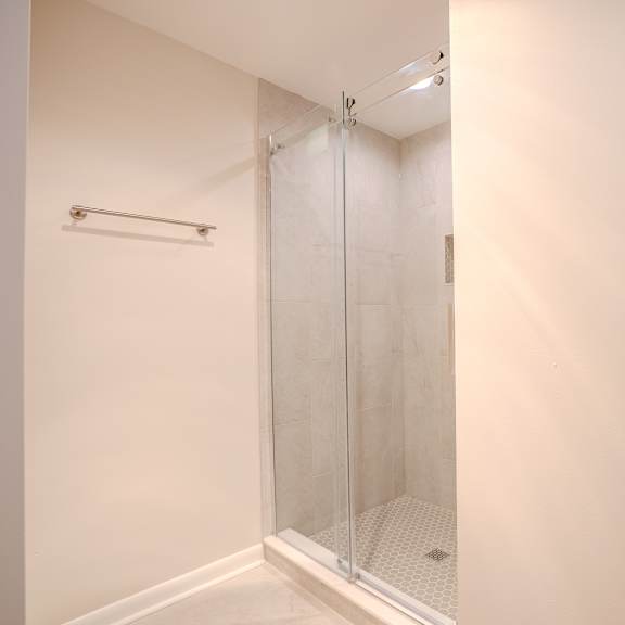 a white bathroom with a glass shower door t atrium in the village, beachwood, oh 44122