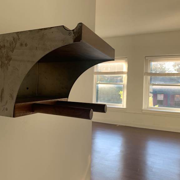 a custom bike rack is mounted on a white wall.
