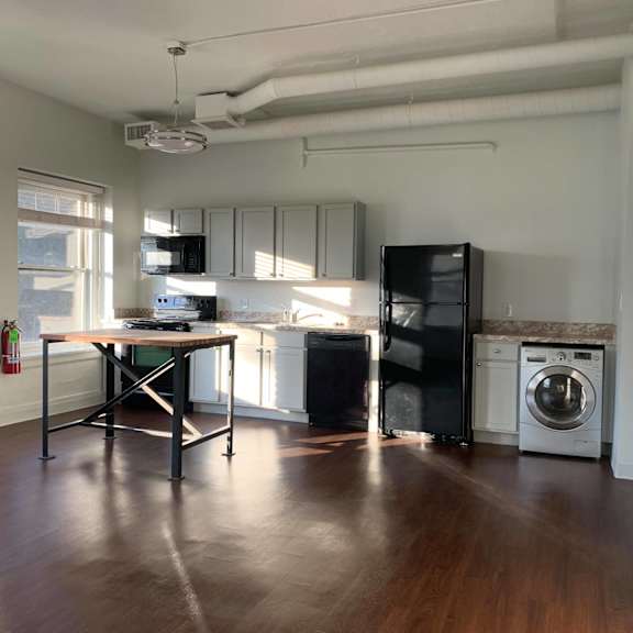 a kitchen with a table and a fridge.