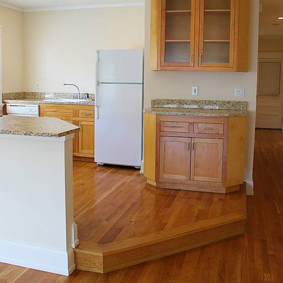a kitchen with wooden floors and a white refrigerator
