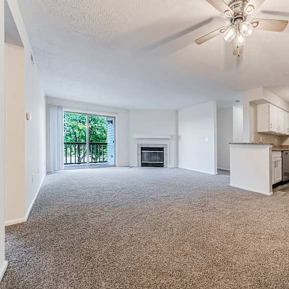 carpeted living area with updated kitchen. at hunt club apartments, copley, ohio