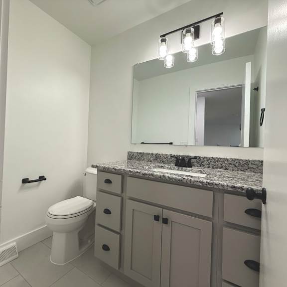 a bathroom with a toilet, sink, and mirror old green place apartments, beachwood, oh