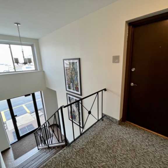 a view from the top of the stairs looking down at the door