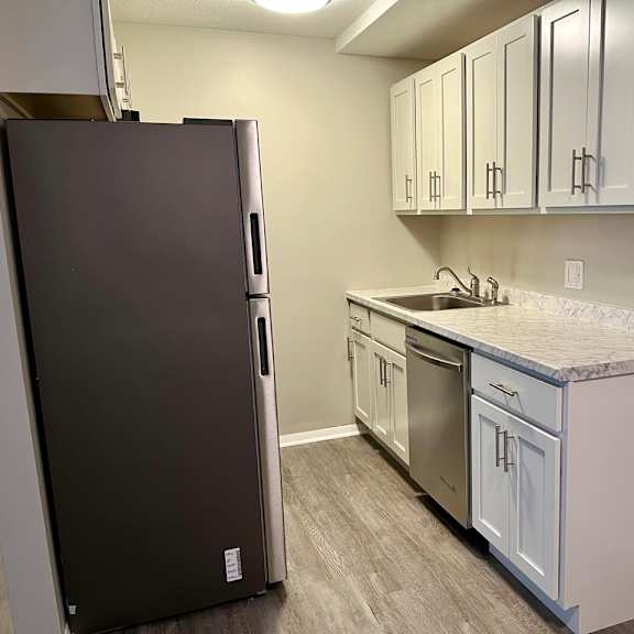 a kitchen with white cabinets and a stainless steel refrigerator