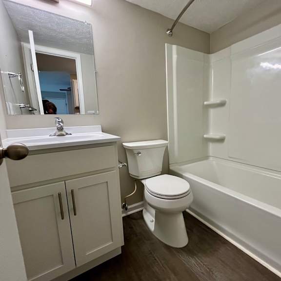 a bathroom with a toilet and a tub and a sink