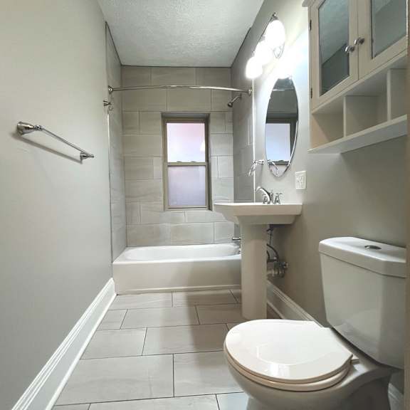 a white toilet sits in a bathroom with a white sink and a white bathtub at integrity cleveland heights apartments, cleveland heights, oh, 44106