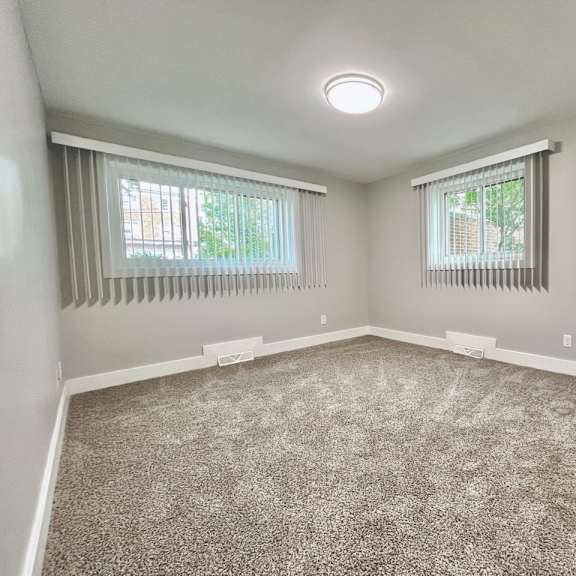a room with a carpeted floor and two windows with blinds old green place apartments, beachwood, oh