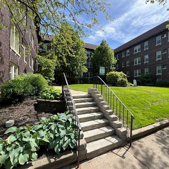 a set of stairs leads up to a grassy area in front of a brick building. at integrity cleveland heights apartments, cleveland heights, ohio
