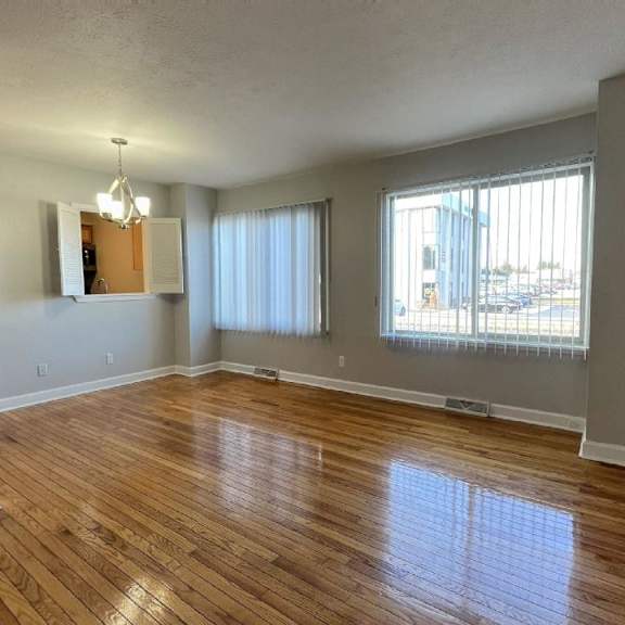 an empty living room with a hardwood floor