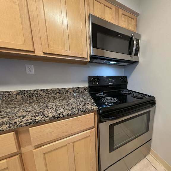 a kitchen with a stove top oven and a microwave