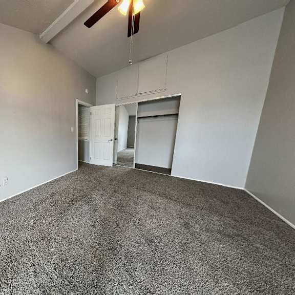 an empty living room with a ceiling fan