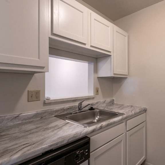 the kitchen of a home with white cabinets and a sink