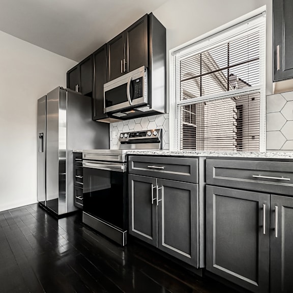 a black and white kitchen with a stainless steel refrigerator and oven.