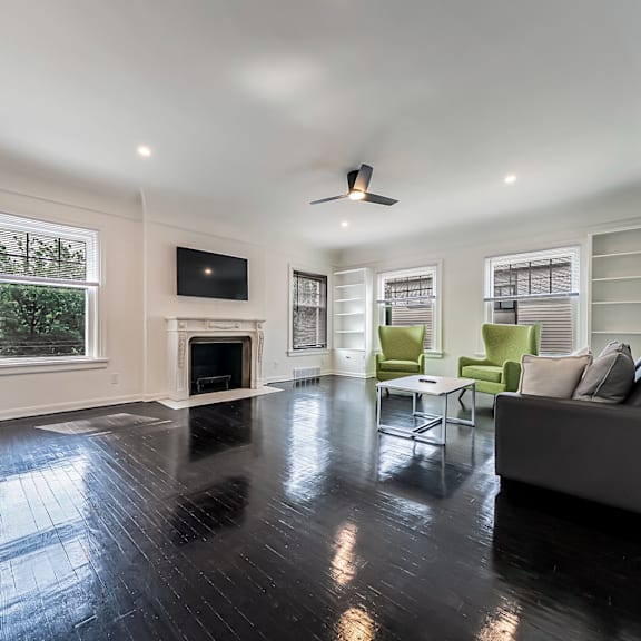 a living room with a fireplace and a grey couch.