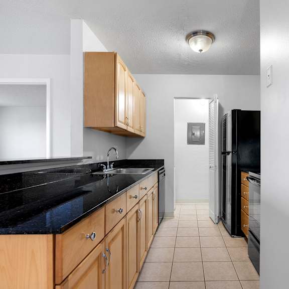 a kitchen with black countertops and wooden cabinets at integrity medina apartments, medina, oh,  44256