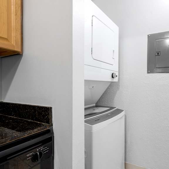 a white washing machine is in a small room with a metal vent on the wall at integrity medina apartments, medina, oh,  44256