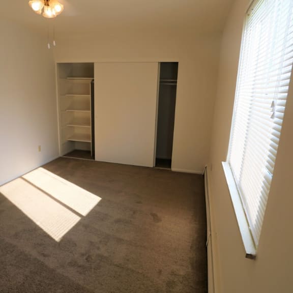 an empty room with a closet and a window