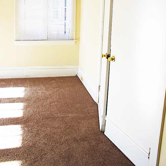 a room with a white door and a window with blinds.