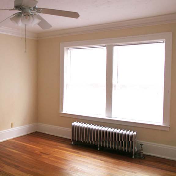 a room with a ceiling fan and a radiator on the floor.