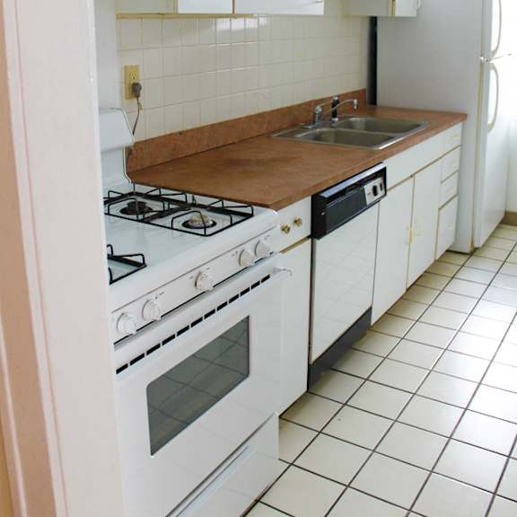 a kitchen with white appliances and a brown counter top.