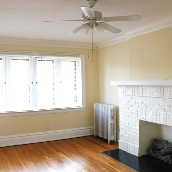 a room with a fireplace and a ceiling fan.