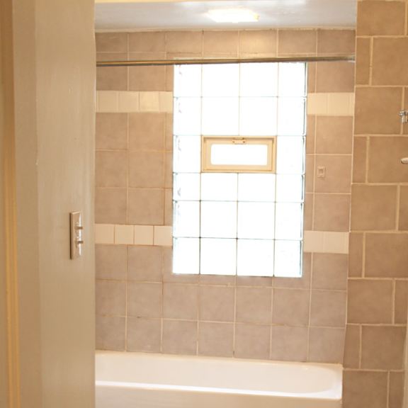 a white toilet sits next to a bathtub in a bathroom.