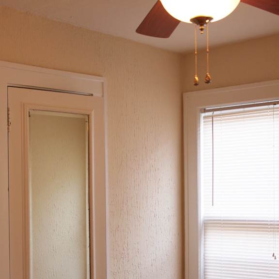 a room with a door and a window with blinds.