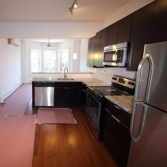 a kitchen with a refrigerator, microwave, and oven.