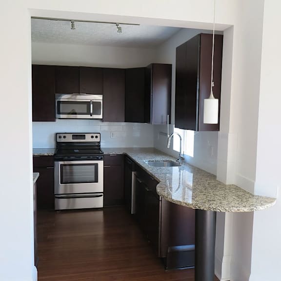 a kitchen with a marble countertop and stainless steel appliances.