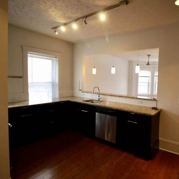 a kitchen with black cabinets and a granite countertop.