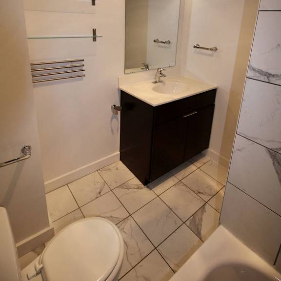 a white toilet sits next to a sink in a bathroom.