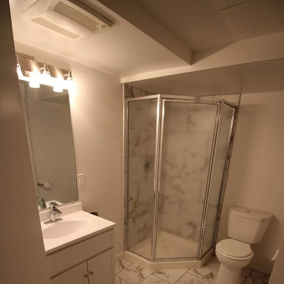 a bathroom with a marble floor and a walk-in shower.