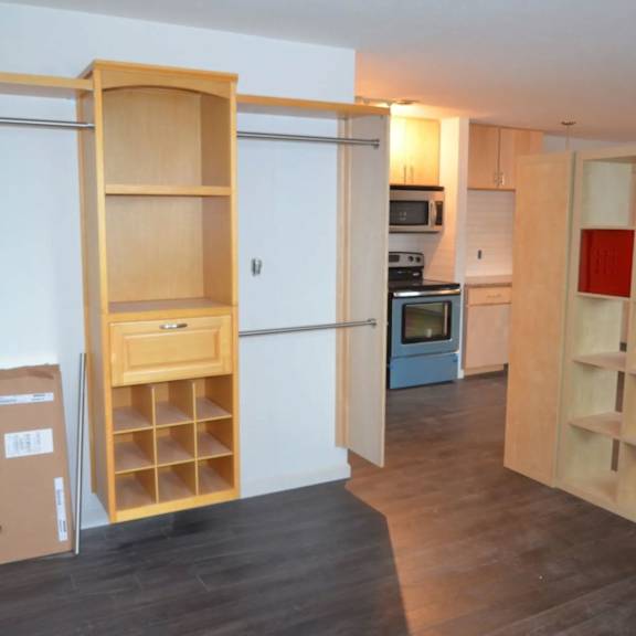 a kitchen with a wooden floor and a white wall.