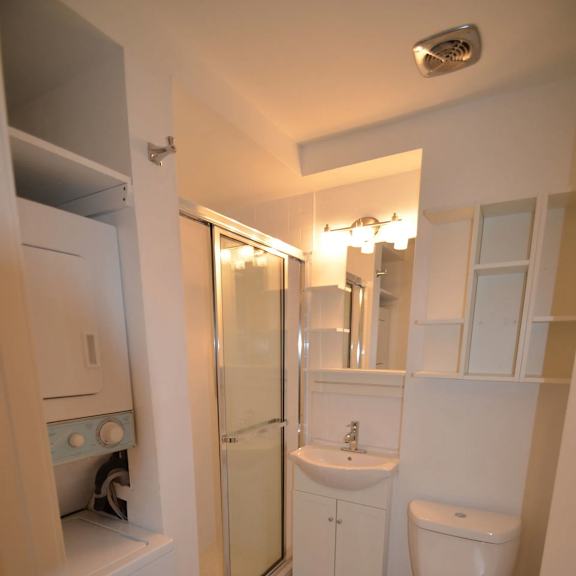 a white toilet is in a bathroom with a sink and a shower.