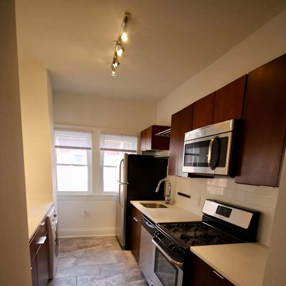 a kitchen with brown cabinets and a black stove top oven.