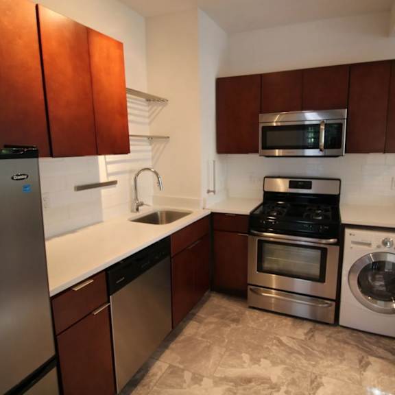 a kitchen with brown cabinets and stainless steel appliances.