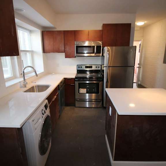 a kitchen with brown cabinets and a white counter.