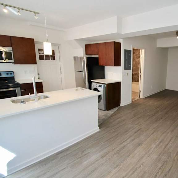 a kitchen with white countertops and wooden floors.