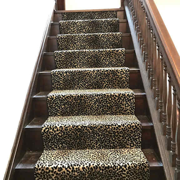 a staircase with leopard print stairs and wooden railings.
