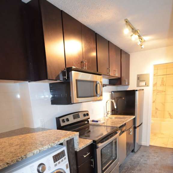 a kitchen with black cabinets and a white washing machine.