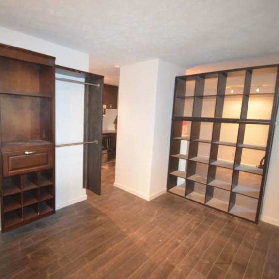 a room with a wooden floor and a brown cabinet with a drawer.