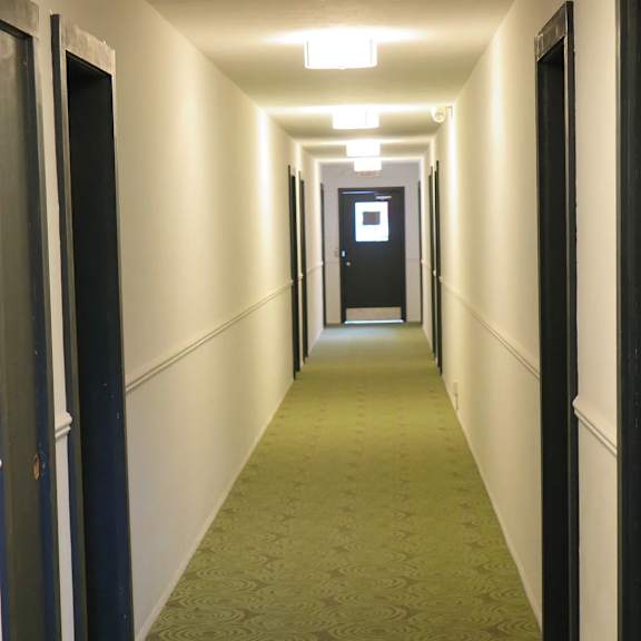 a long hallway with doors on both sides.
