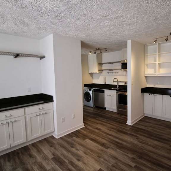 a kitchen with white cabinets and a black countertop.