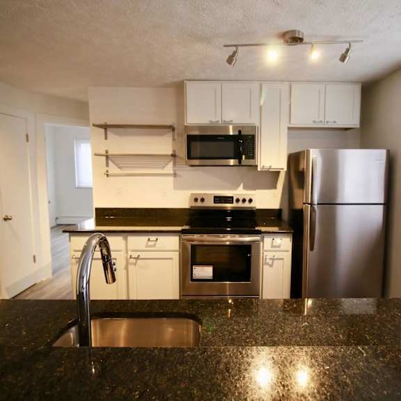 a kitchen with a stainless steel refrigerator, microwave, and oven.