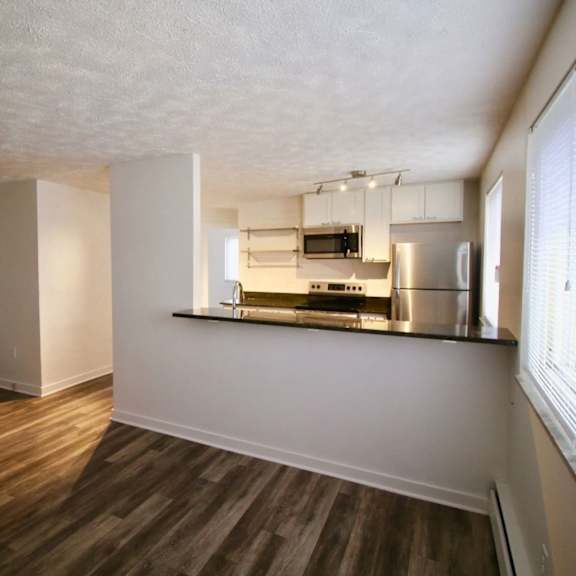 a kitchen area with a stainless steel counter and a microwave.