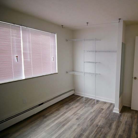 a room with a window, a door, and a shelf.